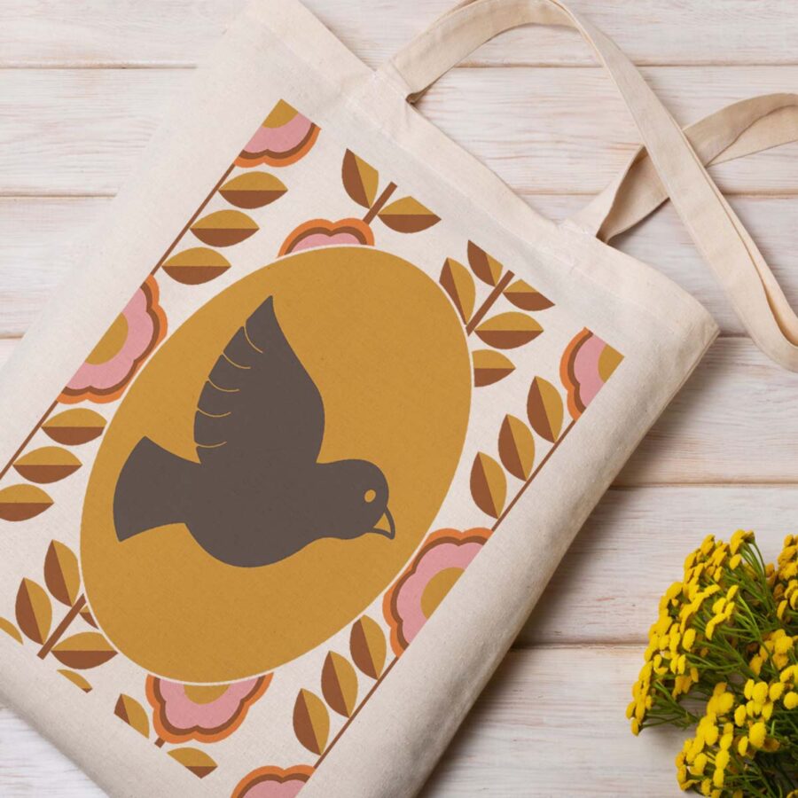 01-6-a-peace-dove-tee-shirt-graphics-free-png-web A cream canvas tote bag featuring a large peace dove in the center, surrounded by a retro floral pattern with pink flowers and brown leaves. The design has a 1960s-inspired, vintage aesthetic.