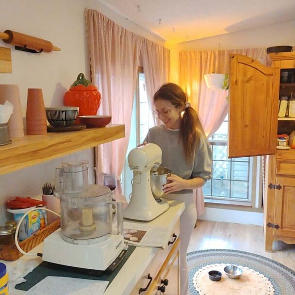 Fair skin red headed woman miking cookie dough in modern rustic kitchen